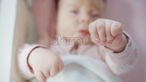 Video - Close up of baby's tiny hand reaching out gently in soft pastel tones