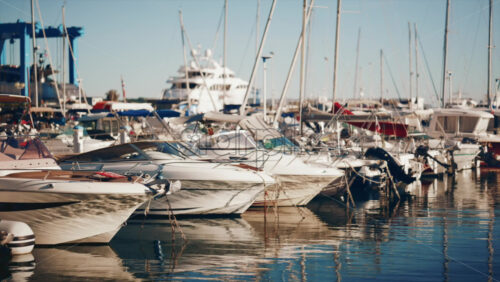 Video - View of yachts and boats moored in a sunny marina under clear blue sky
