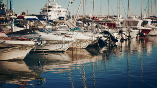 Video - View of yachts and boats moored in a sunny marina under clear blue sky