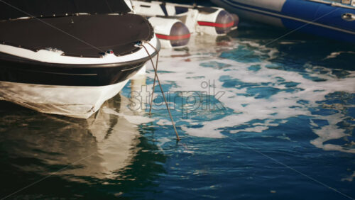 Video - Close up of a boat's bow surrounded by sea foam in sunlight