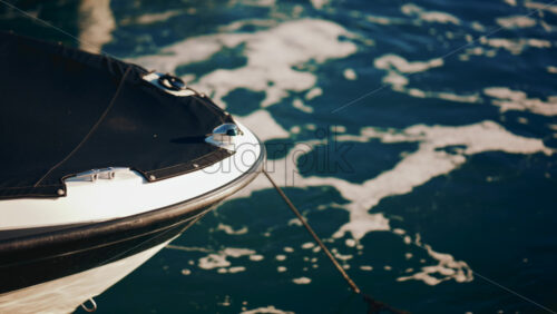 Video - Close up of a boat's bow surrounded by sea foam in sunlight