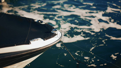 Video - Close up of a boat's bow surrounded by sea foam in sunlight