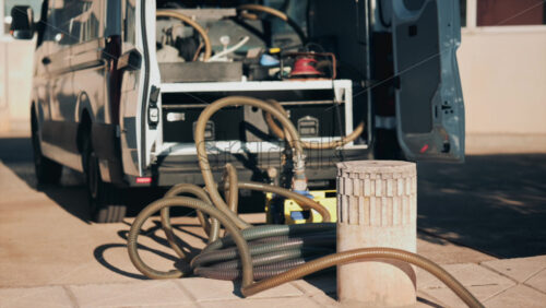 Video - Parked work van with hoses and industrial tools in sunlight