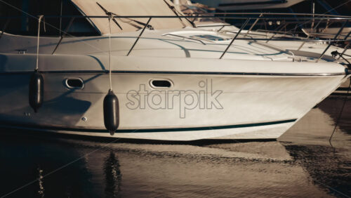 Video - Close up of a white yacht reflecting sunlight on calm water