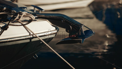 Video - Close up of a polished chrome anchor with ropes on a luxury boat docked in the marina