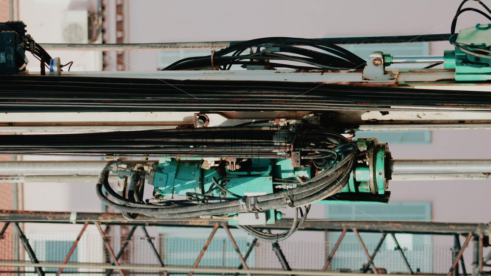 Video - Close up of industrial drilling equipment with hydraulic cables and metal framework