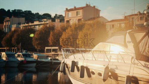 Video - Close up of a white yacht with fenders along its side, bathed in golden evening light