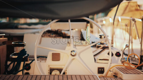 Video - Close up view of a sailboat cockpit with ropes, steering wheel, and control levers