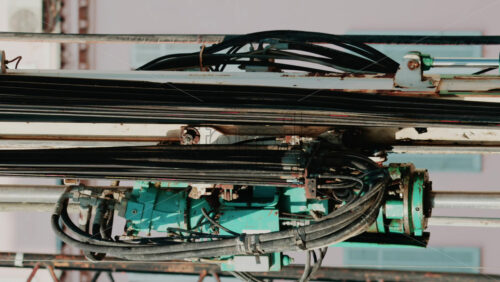 Video - Close up of industrial drilling equipment with hydraulic cables and metal framework
