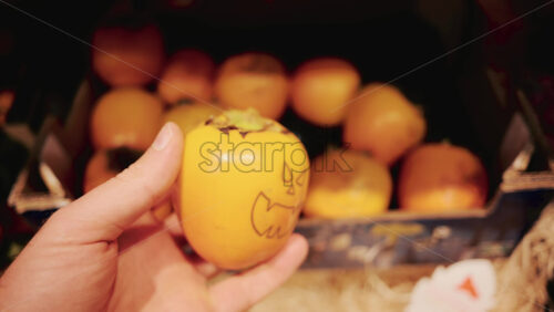 Video - Close up of a person selecting fresh kiwi fruit from a pile in a supermarket