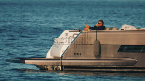 Video - Cannes, France - October 16, 2025: Side view of a sleek metallic yacht reflecting sunlight on calm blue water