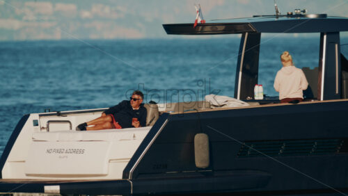 Video - Cannes, France - October 16, 2025: Man lying shirtless on a motorboat floating on calm blue water under sunlight