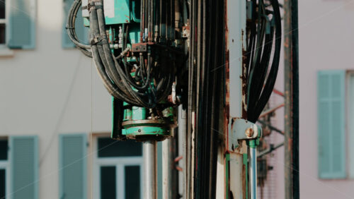 Video - Close up of mechanical parts and hydraulic hoses of a construction drill