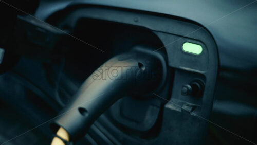 Video - Close up of an electric car being charged, with cable plugged into port