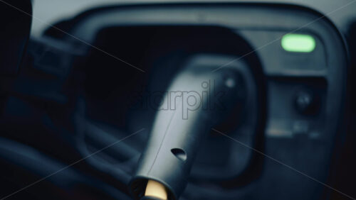 Video - Electric vehicle plugged into charging port in daylight