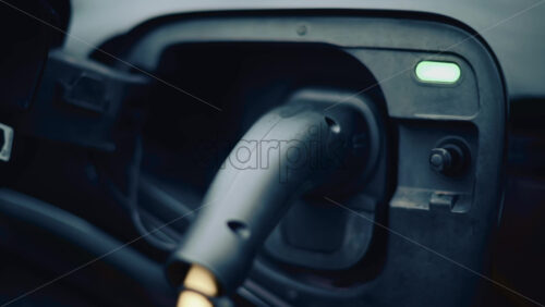 Video - Electric vehicle plugged into charging port in daylight