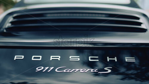 Video - Cannes, France - October 16, 2025: Close up of the rear of a Porsche 911 Carrera S luxury sports car with metallic reflections