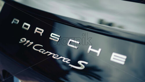 Video - Cannes, France - October 16, 2025: Close up of the rear of a Porsche 911 Carrera S luxury sports car with metallic reflections