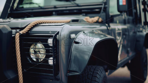 Video - Close up of a rugged off road vehicle with a thick rope across its hood