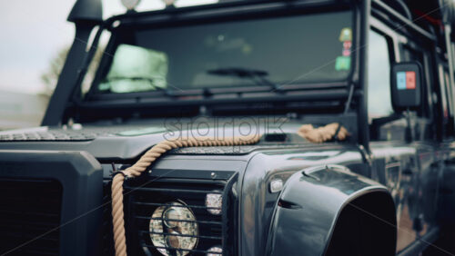 Video - Close up of a rugged off road vehicle with a thick rope across its hood