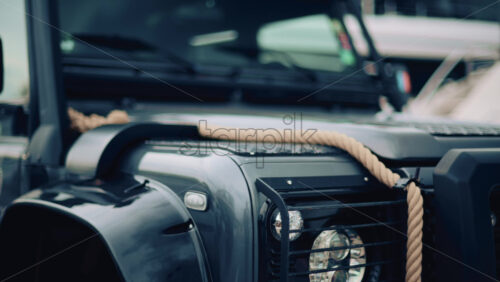 Video - Close up of a rugged off road vehicle with a thick rope across its hood