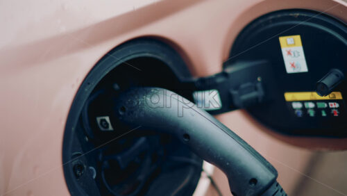 Video - Close up of an electric car charging port with cable plugged in