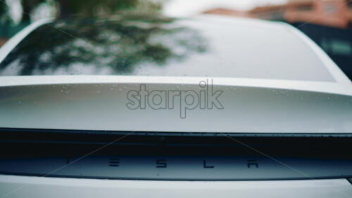Video - Cannes, France - October 16, 2025: Close up of a Tesla rear detail covered in raindrops