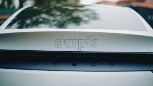 Video - Cannes, France - October 16, 2025: Close up of a Tesla rear detail covered in raindrops