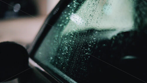 Video - Raindrops on a car window illuminated by city lights