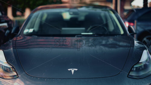 Video - Cannes, France - October 16, 2025: Close up of a black Tesla Model 3 hood glistening with water droplets after the rain