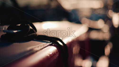 Video - Close up of a boat deck during sunset, with a focus on a black rope coiled on the surface