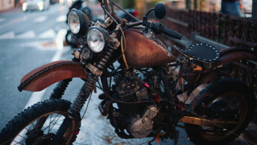Video - Close up of a vintage rusty motorcycle parked on a city street