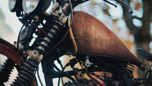 Video - Close up of a vintage rusty motorcycle parked on a city street