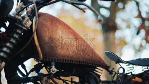 Video - Close up of a vintage rusty motorcycle parked on a city street