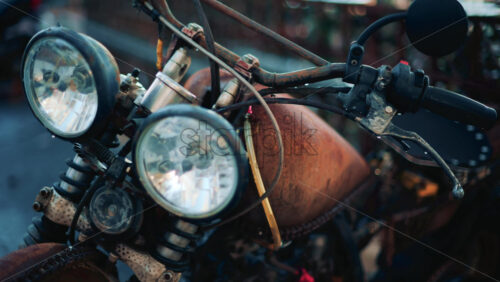 Video - Close up of a vintage rusty motorcycle parked on a city street