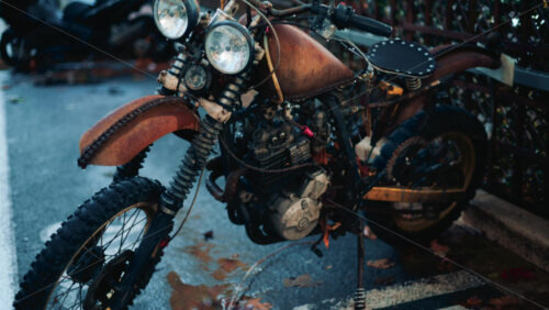 Video - Close up of a vintage rusty motorcycle parked on a city street