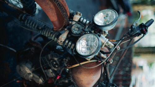 Video - Close up of a vintage rusty motorcycle parked on a city street