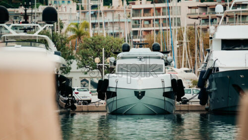 Video - A modern white yacht docked in a marina, viewed from the front