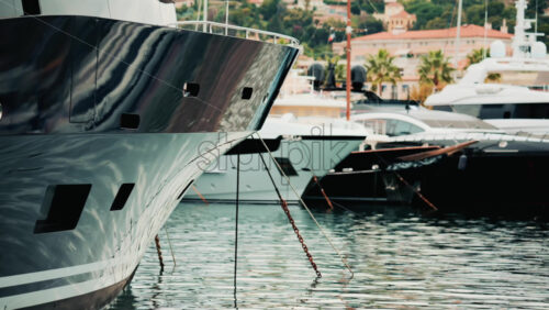Video - Close up of a yacht's metallic hull reflecting the surrounding marina and water ripples