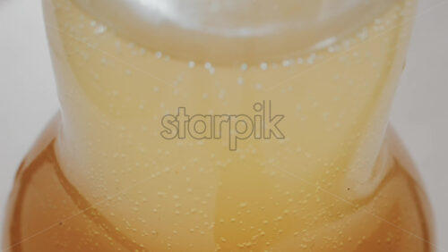 Video - Close up view of fizzy drink with golden bubbles rising inside a glass