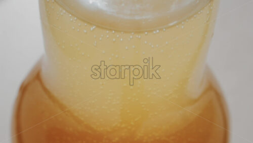 Video - Close up view of fizzy drink with golden bubbles rising inside a glass