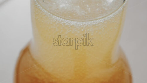 Video - Close up view of fizzy drink with golden bubbles rising inside a glass