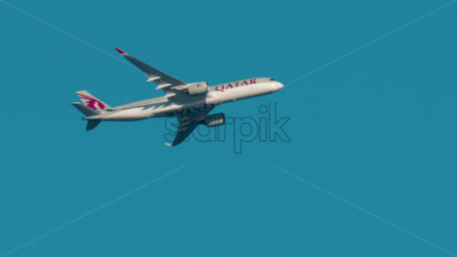 Video - Cannes, France - October 4, 2025: Commercial Quatar airplane flying through clear blue sky on sunny day