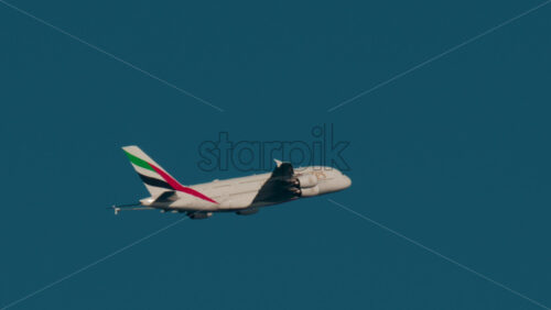 Video - Cannes, France - October 4, 2025: Emirates airplane flying across clear blue sky