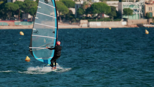 Video - Cannes, France - October 5, 2025: Athlete windsurfing on turquoise sea on a sunny day