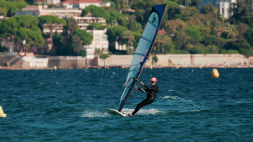 Video - Cannes, France - October 5, 2025: Athlete windsurfing on turquoise sea on a sunny day