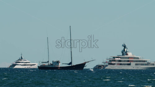 Video - Multiple luxury yachts anchored on the blue Mediterranean Sea near the French Riviera coast