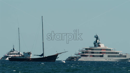 Video - Multiple luxury yachts anchored on the blue Mediterranean Sea near the French Riviera coast