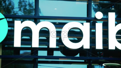 Video - Chisinau, Moldova - October 1, 2025: Modern glass building facade with the illuminated maib logo