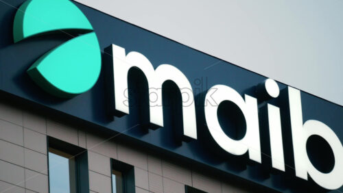 Video - Chisinau, Moldova - October 1, 2025: Modern glass building facade with the illuminated maib logo